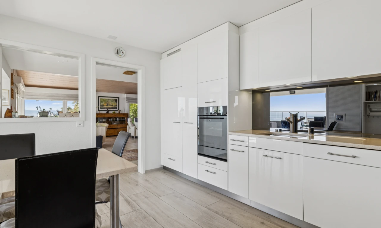 cuisine avec light countertops, plans de travail, white cabinets, armoires blanches, et day time