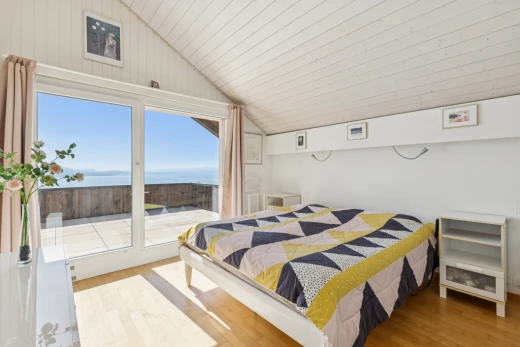 chambre avec vaulted ceiling, plafond voûté, pièce supplémentaire, wood finish floor, et sol en finition bois