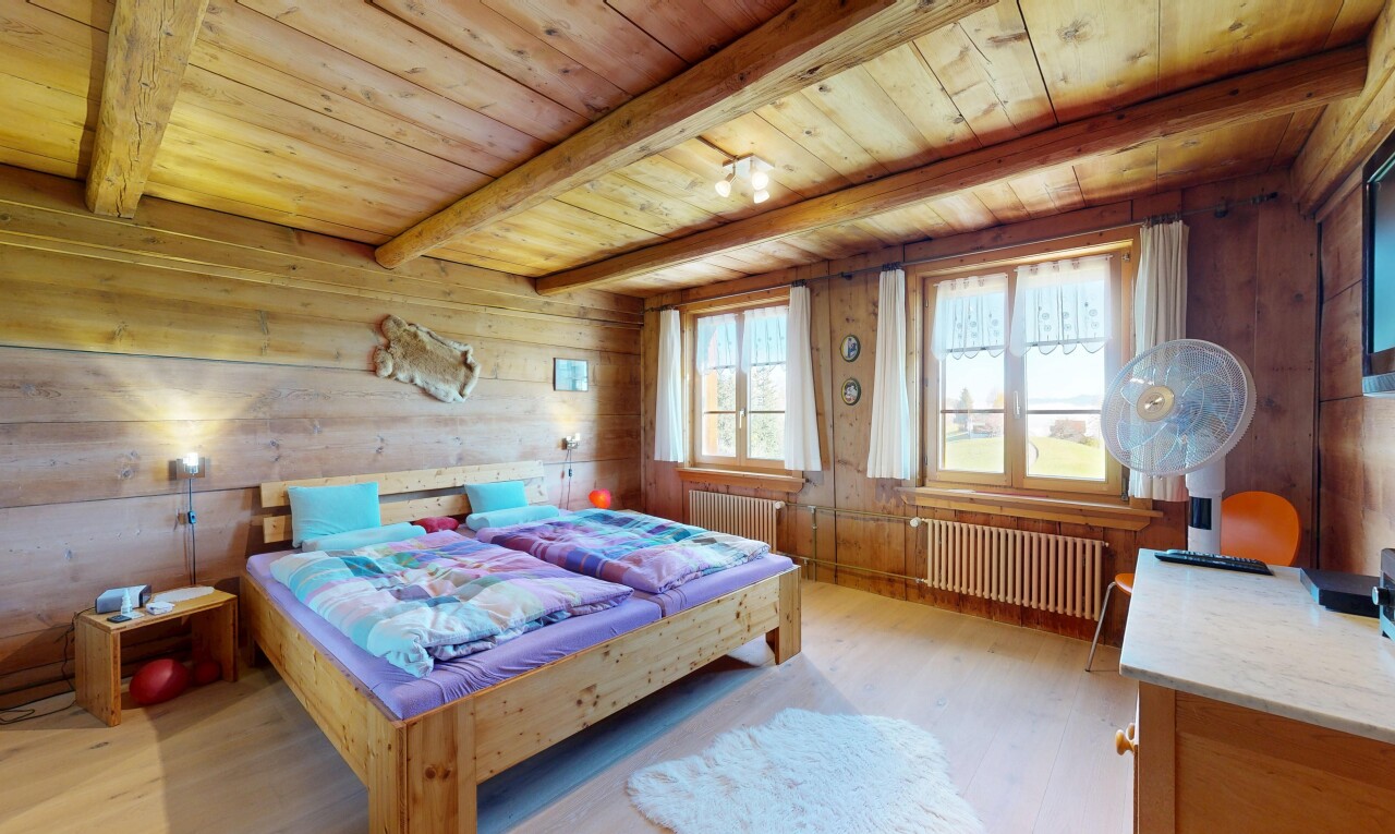 room with a wooden ceiling with exposed beams, wood walls, radiator heating unit, and light wood-style flooring