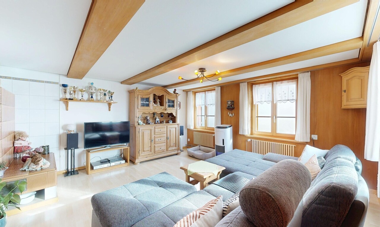 living room with radiator and beam ceiling