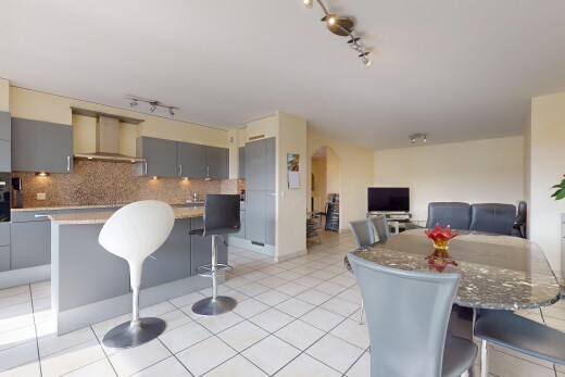 cuisine avec bar de cuisine, armoires grises, îlot de cuisine, dosseret, et backsplash