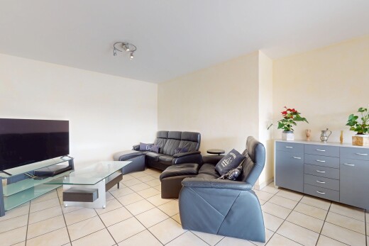 salon avec télévision, cloison sèche, drywall, inside property, et sol en carrelage