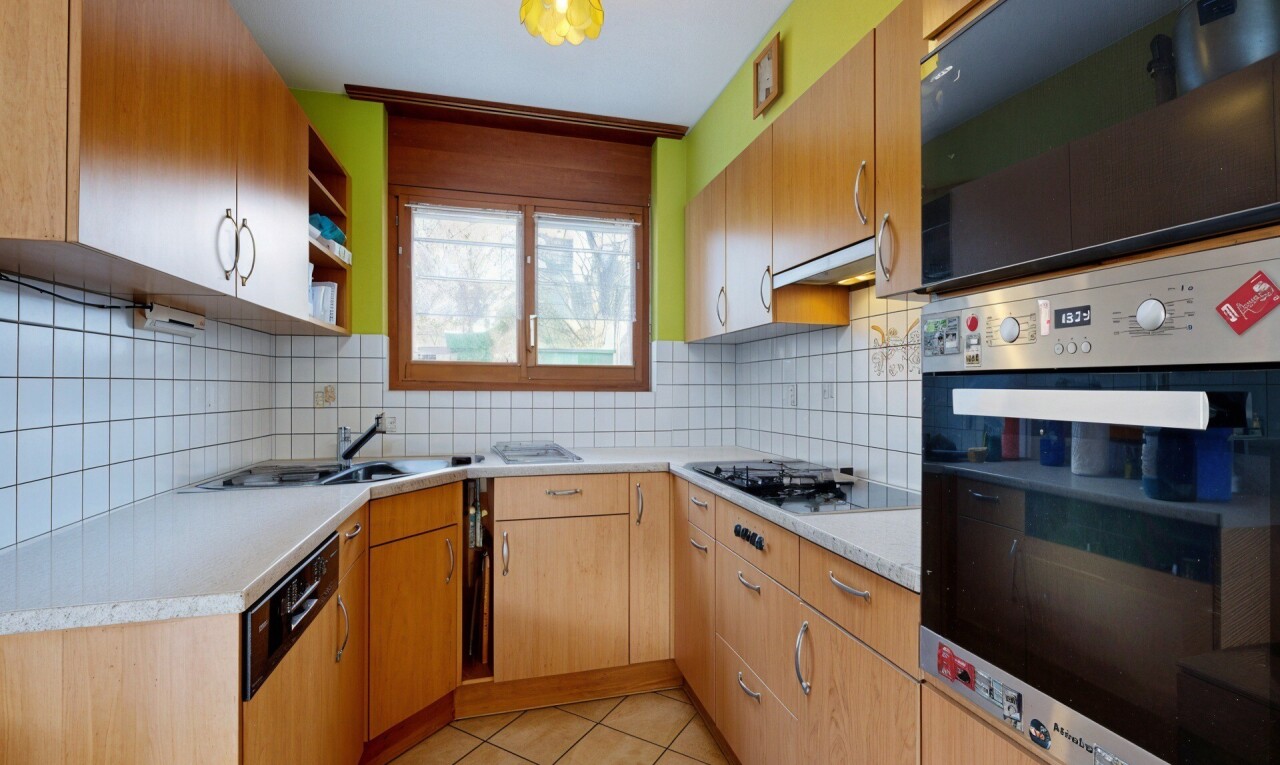 cuisine avec four, light countertops, plans de travail, light floor, et tile floor