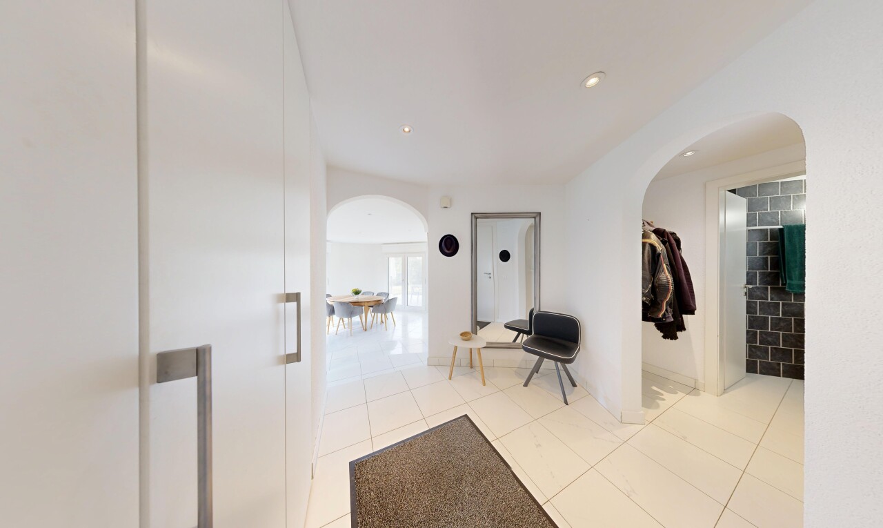 halle / korridor mit gewölbte gehwege, gipskartonwand, drywall, fliesenboden, und tile floor