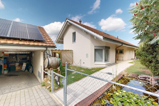 view of home with a tiled roof, a gate, stucco siding, and roof mounted solar panels
