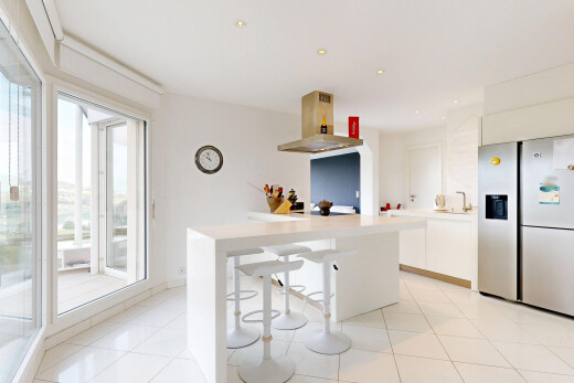 kitchen featuring island range hood, white cabinets, light countertops, recessed lighting, and a breakfast bar