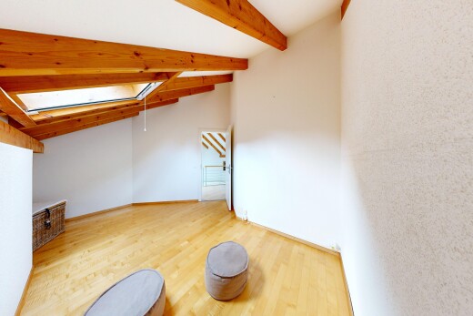 spare room with light wood-type flooring and lofted ceiling with beams