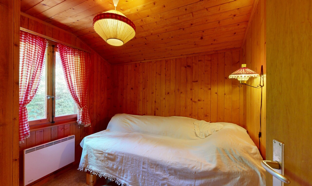 chambre avec radiateur, plafond voûté, vaulted ceiling, mur en bois, et wood wall