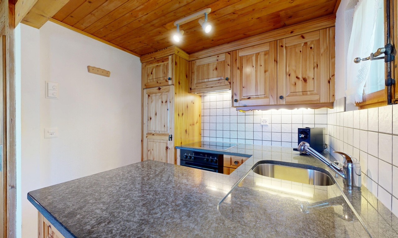 cuisine avec drywall, cloison sèche, raised cabinets, armoires élevées, et dark countertops