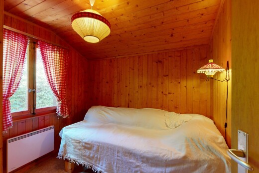 chambre avec radiateur, plafond voûté, vaulted ceiling, mur en bois, et wood wall