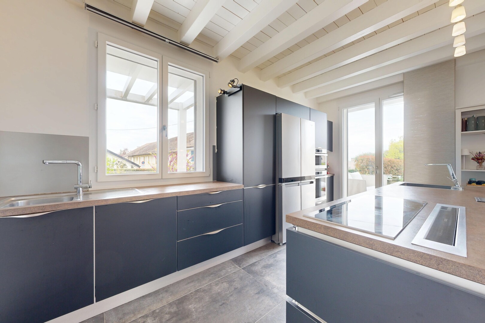 cuisine avec beamed ceiling, plafond à poutres, inside property, flat panel cabinets, et armoires à panneau plat