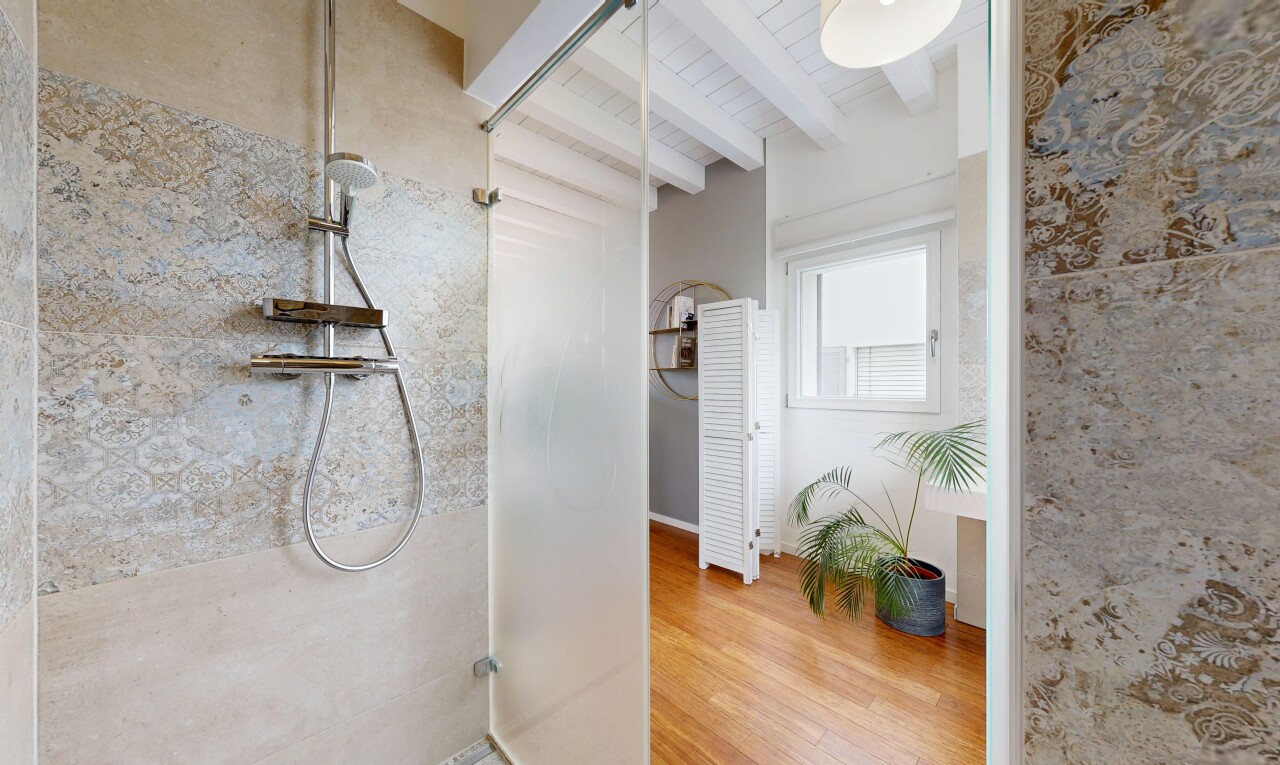 salle de bains avec beamed ceiling, plafond à poutres, douche, wood finish floor, et sol en finition bois