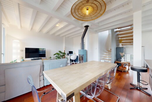 salle à manger avec wood finish floor, sol en finition bois, poêle à bois, télévision, et inside property