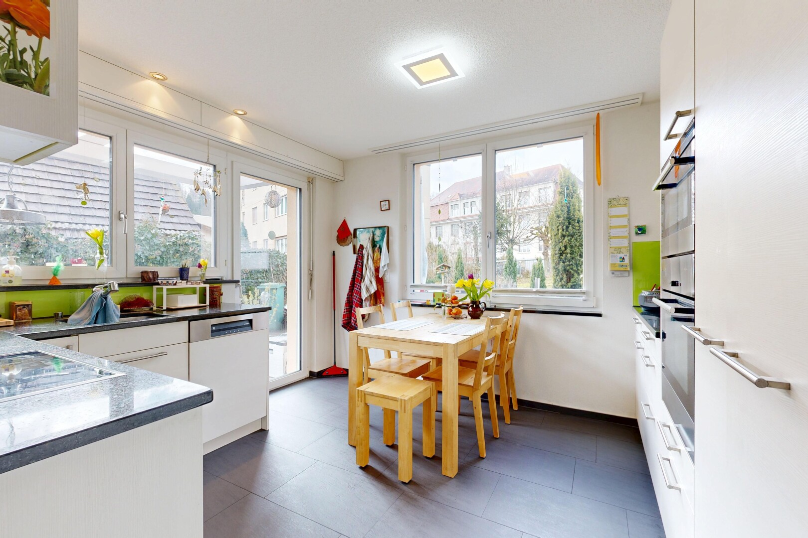 cuisine avec dark floor, white cabinets, armoires blanches, inside property, et natural light