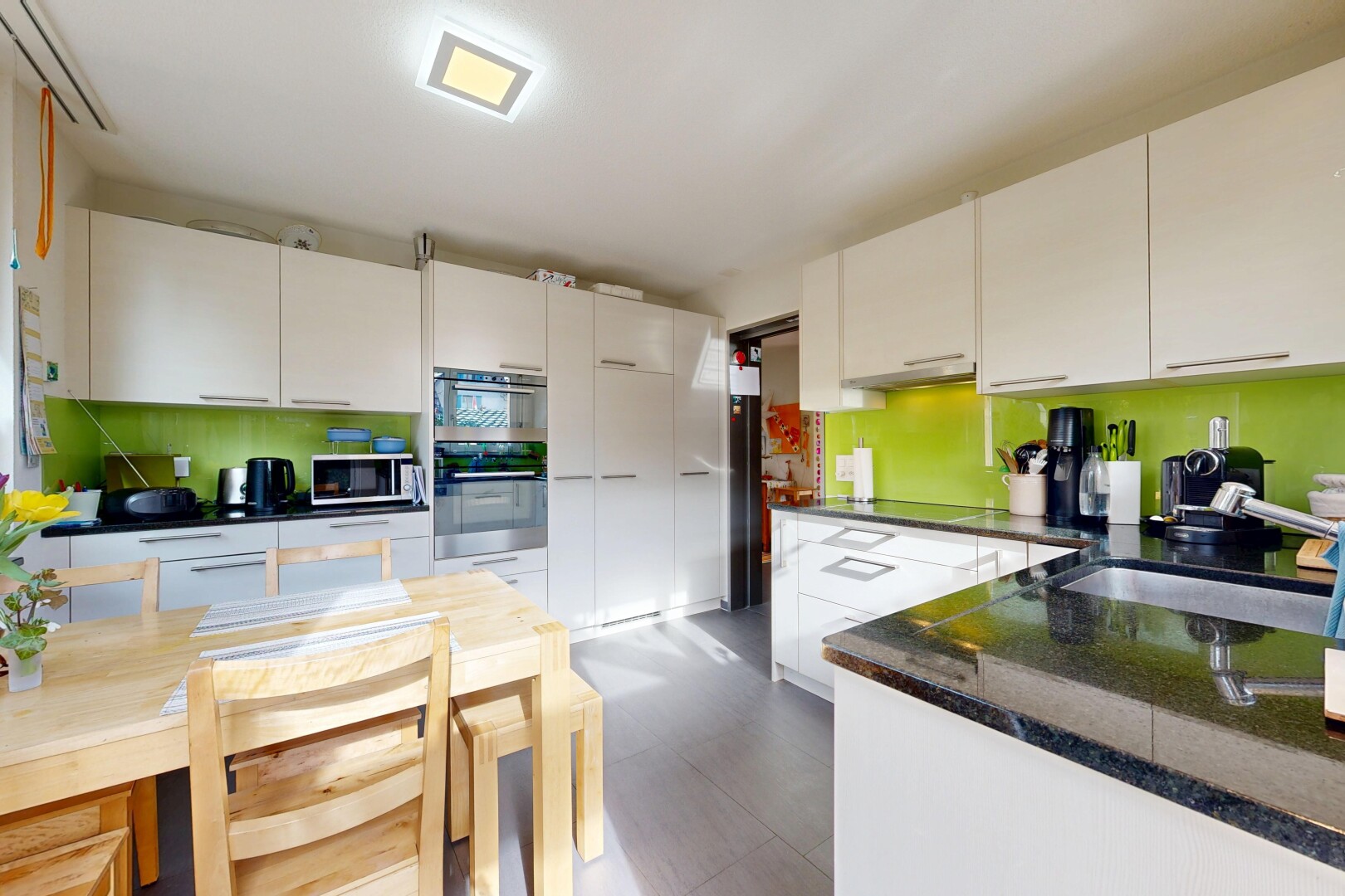 cuisine avec dark countertops, inside property, armoires blanches, white cabinets, et four double