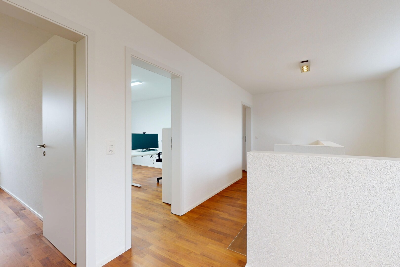 couloir avec wood finish floor, sol en finition bois, drywall, cloison sèche, et inside property