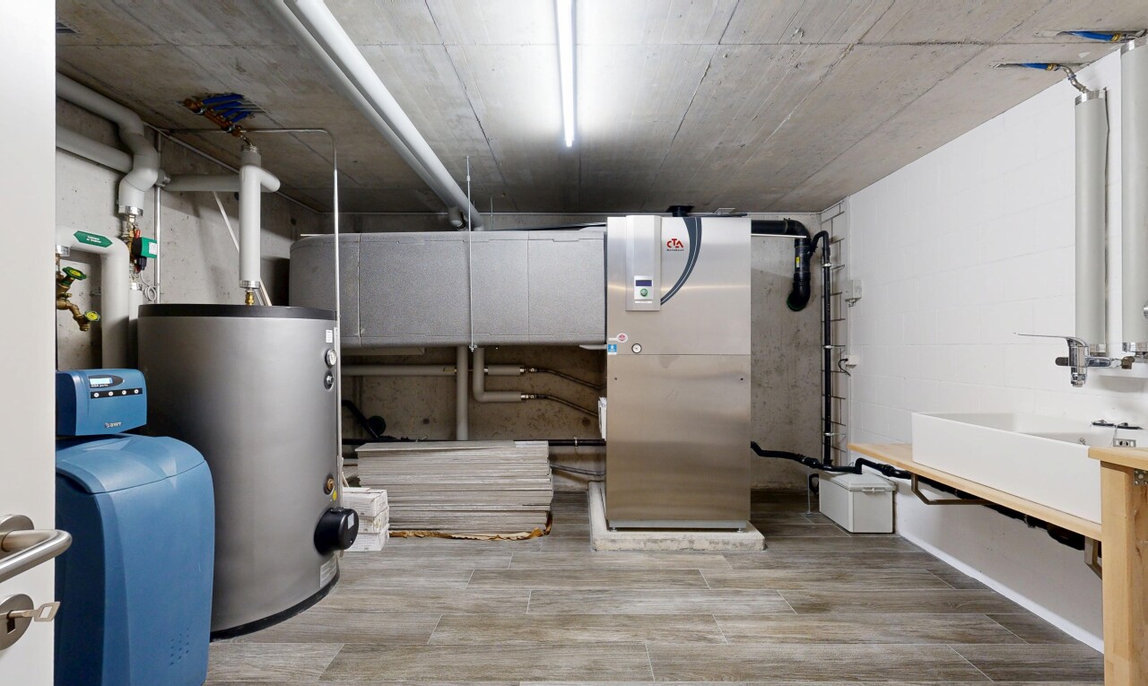 espace intérieur avec concrete ceiling, inside community, chauffe-eau, lavabo (ou coiffeuse selon le contexte), et wood finish floor