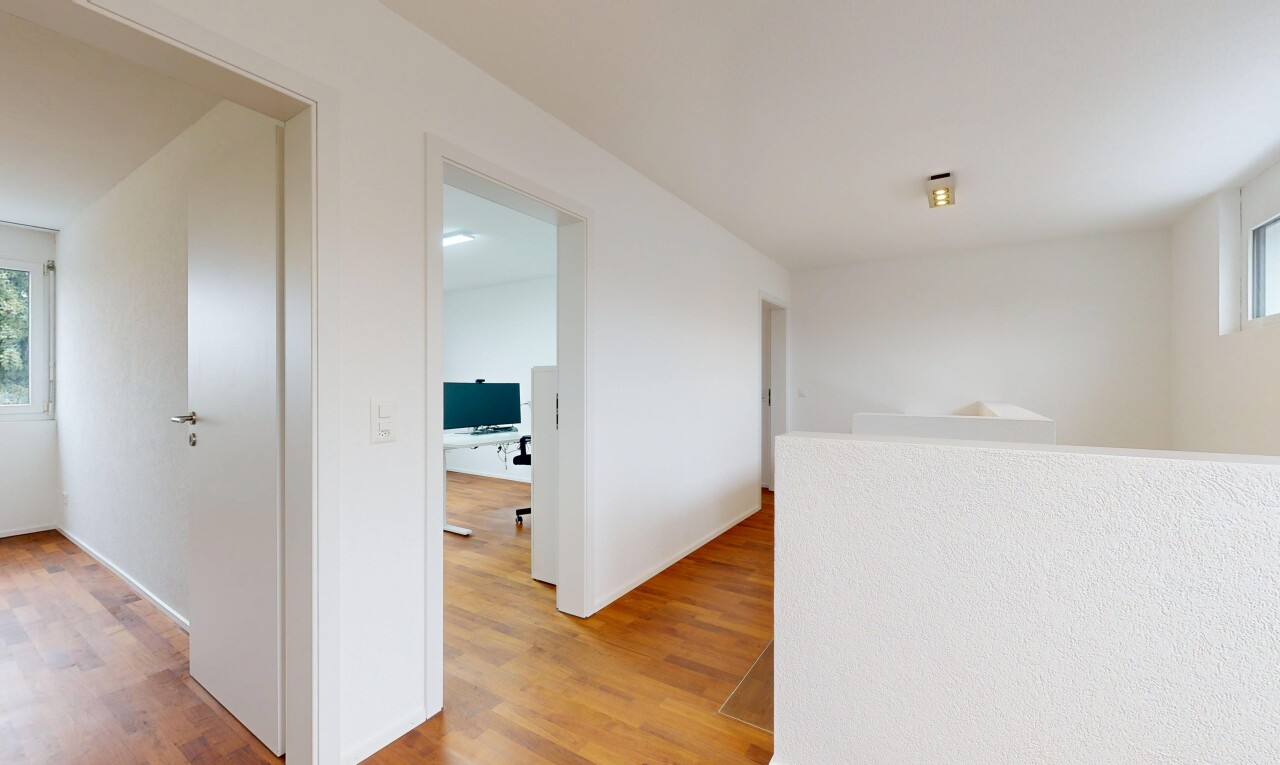 couloir avec wood finish floor, sol en finition bois, drywall, cloison sèche, et inside property