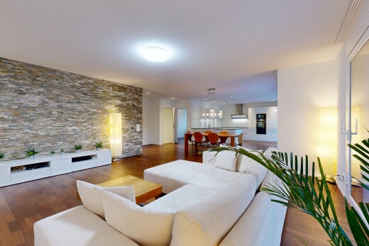 salon / salle à manger avec mur en pierre, stone wall, inside property, sol en finition bois, et wood finish floor