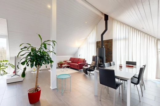 wohn- / esszimmer mit fliesenboden, dachschräge, holzofen, und natürliches licht