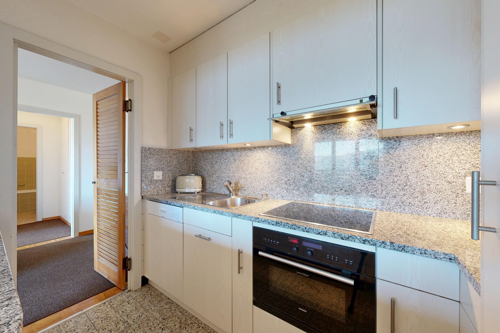 kitchen featuring black appliances, tasteful backsplash, under cabinet range hood, light stone counters, and white cabinets