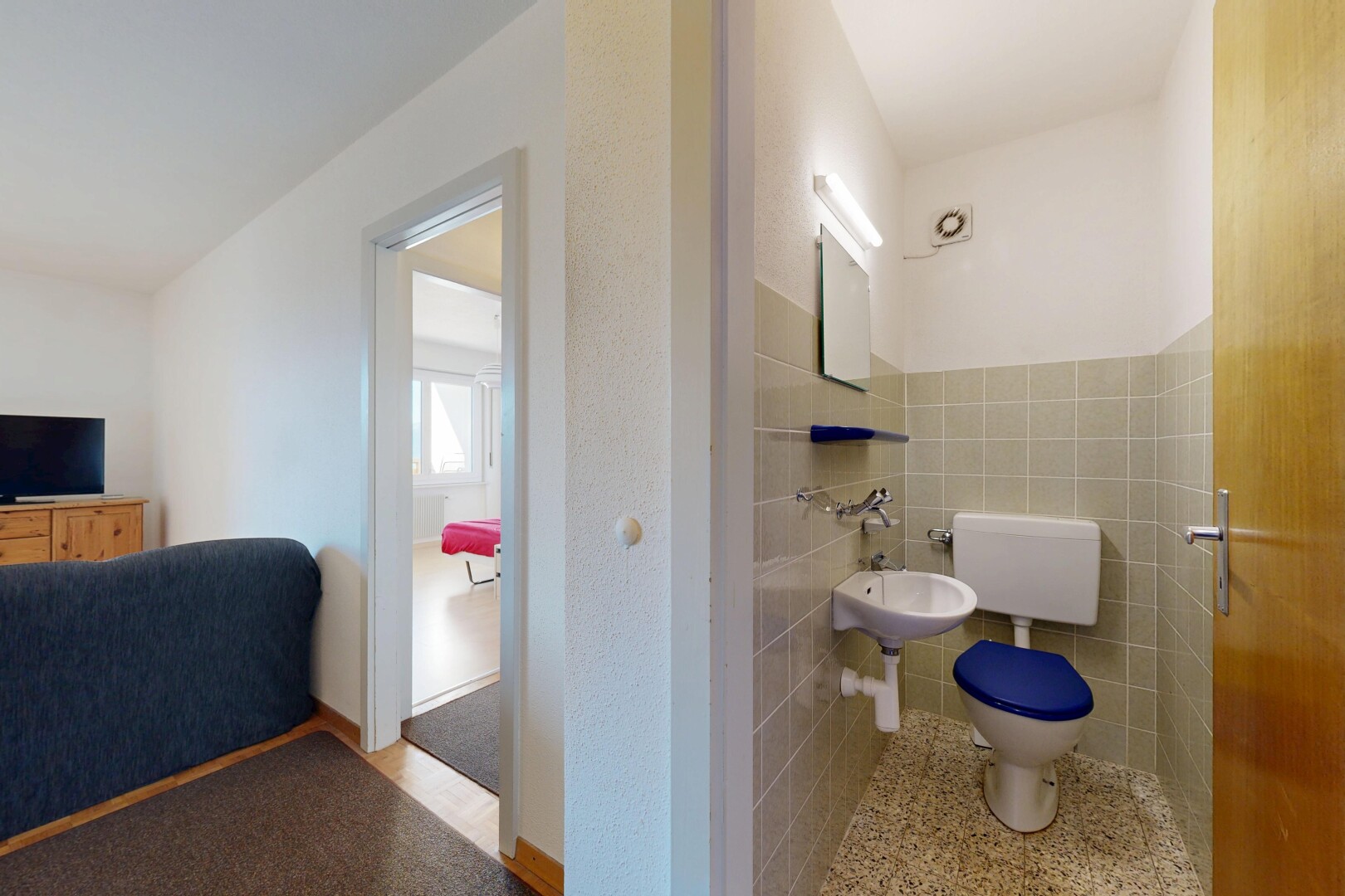 half bathroom with toilet and tile walls