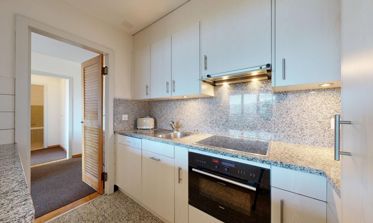 kitchen featuring black appliances, tasteful backsplash, under cabinet range hood, light stone counters, and white cabinets