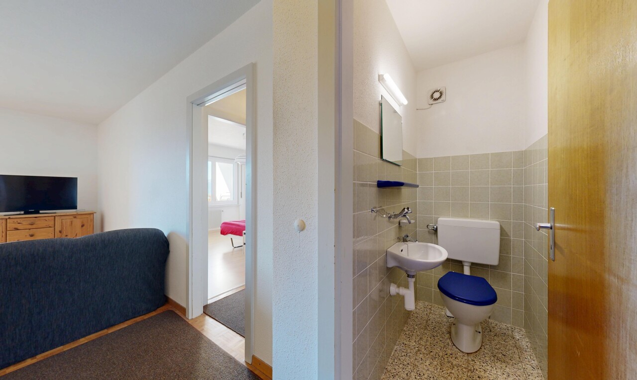 half bathroom with toilet and tile walls