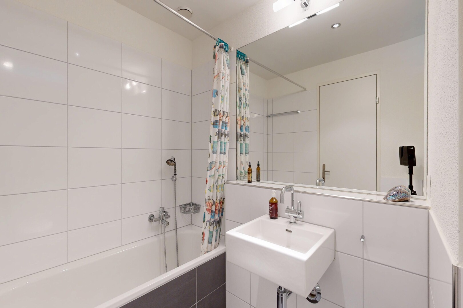 full bath with tiled shower / bath combo and a sink