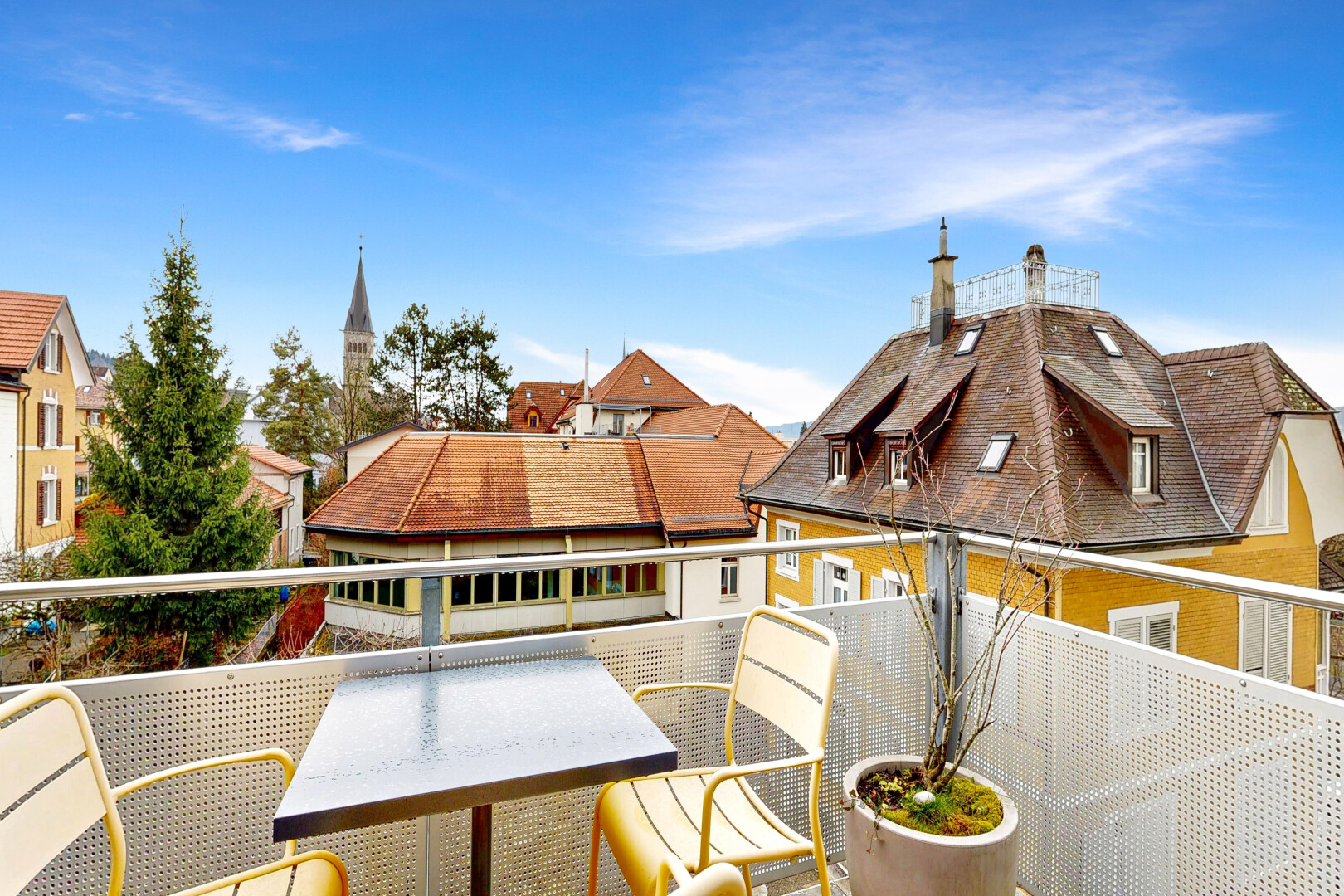 view of home with a balcony and a chimney