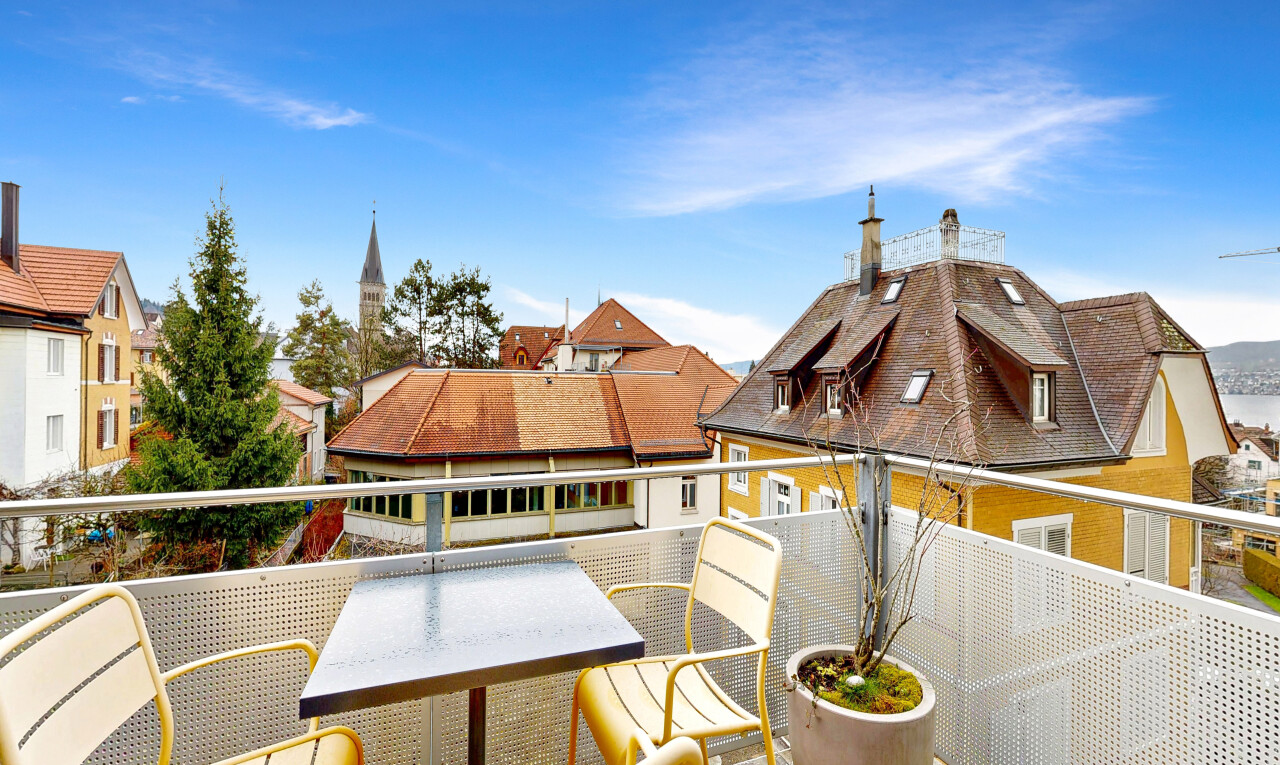 view of home with a balcony and a chimney