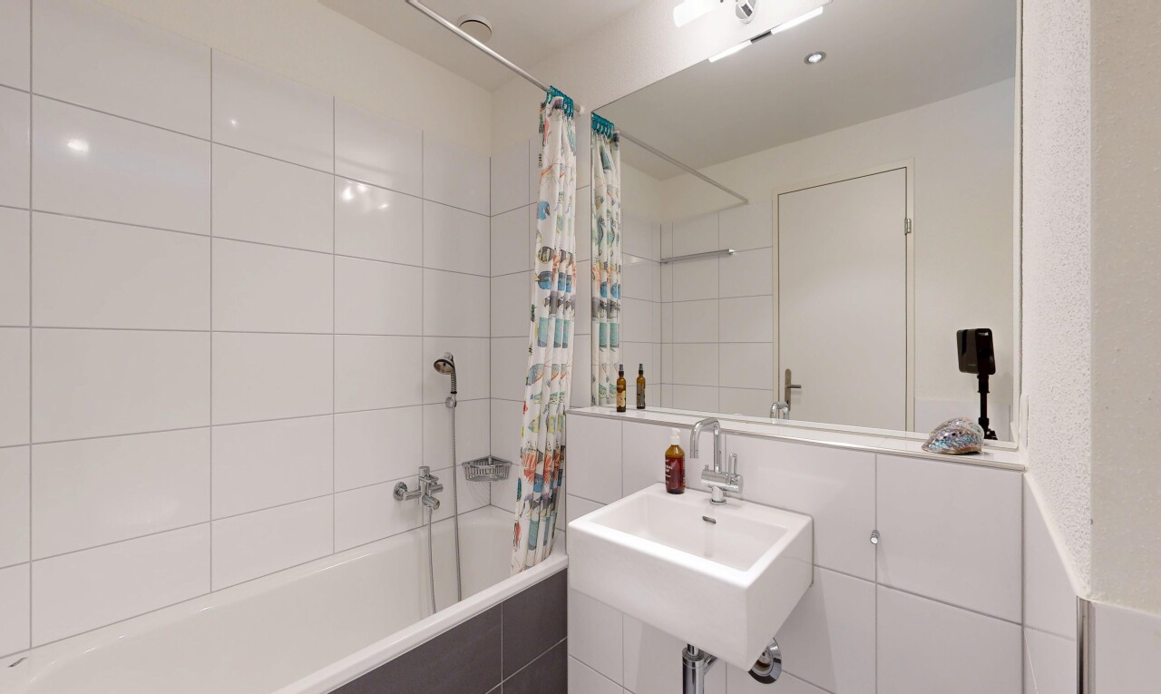 full bath with tiled shower / bath combo and a sink