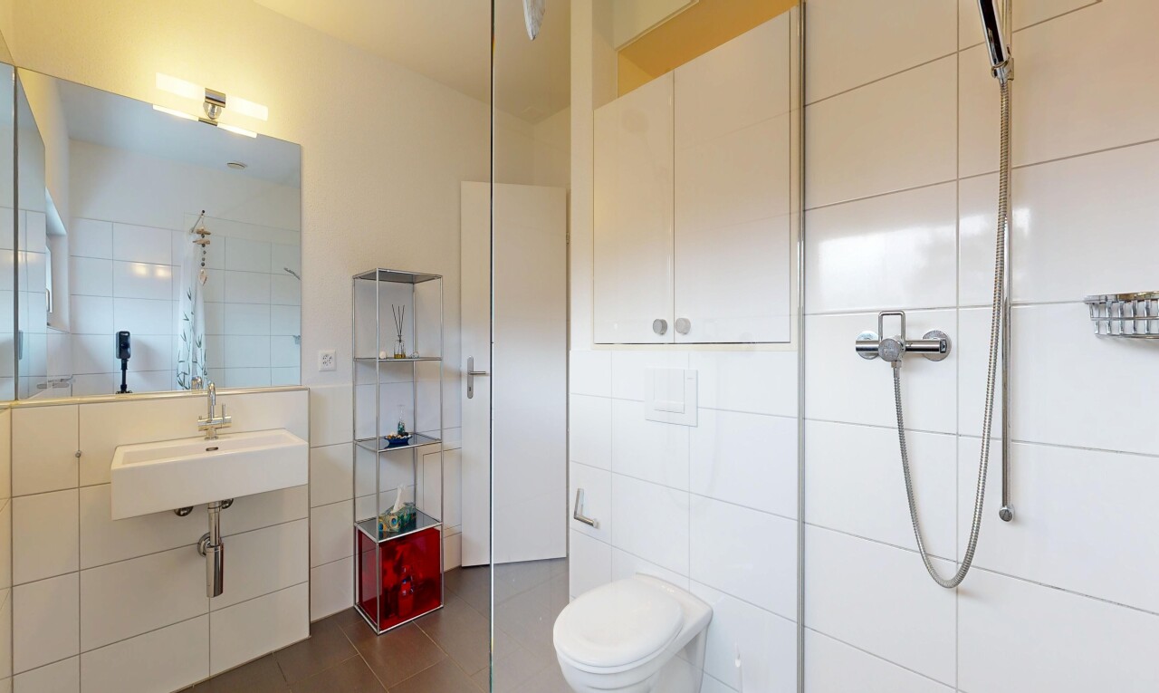 bathroom with tile walls, tiled shower, and dark tile patterned floors