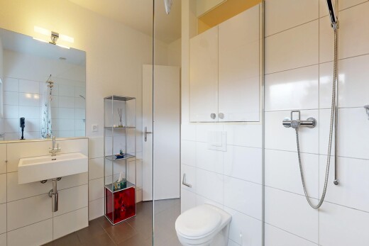 bathroom with tile walls, tiled shower, and dark tile patterned floors