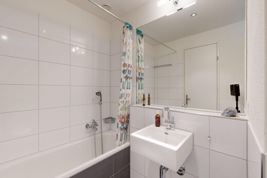 full bath with tiled shower / bath combo and a sink