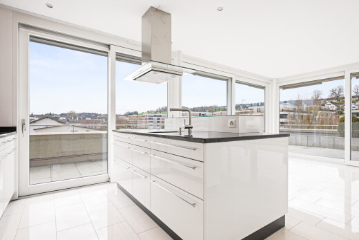 küche mit dunstabzugshaube, weiße schränke, white cabinets, dark countertops, und natürliches licht
