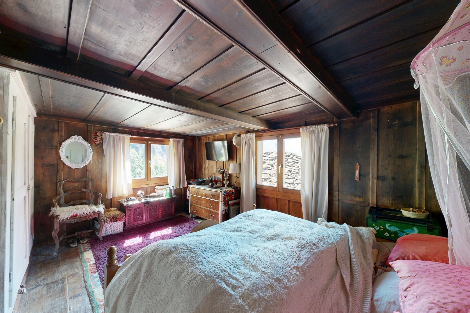 room with a wooden ceiling with exposed beams and wooden walls