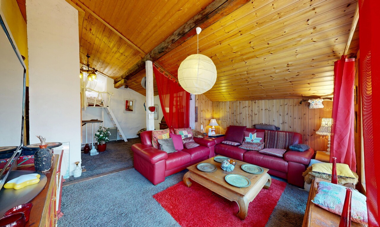 carpeted living room with wood walls and a vaulted wood ceiling