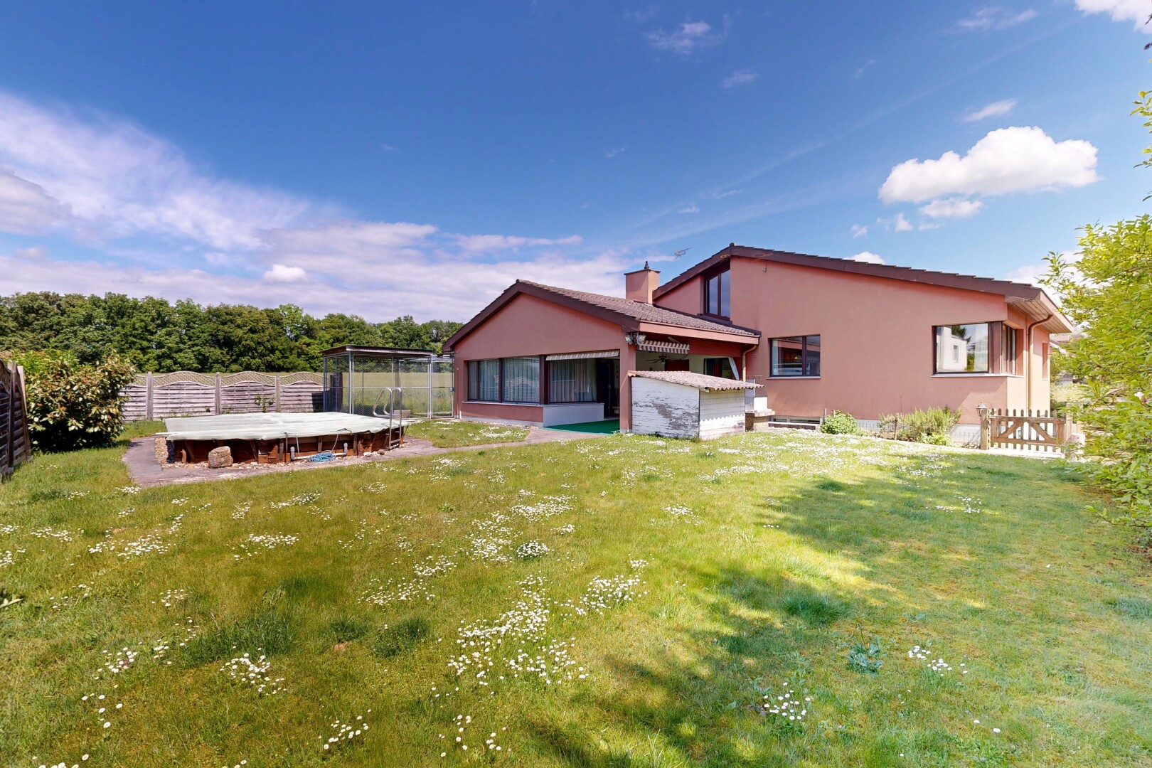außenansicht mit from property, wintergarten, stuckverkleidung, trampolin, und zaun