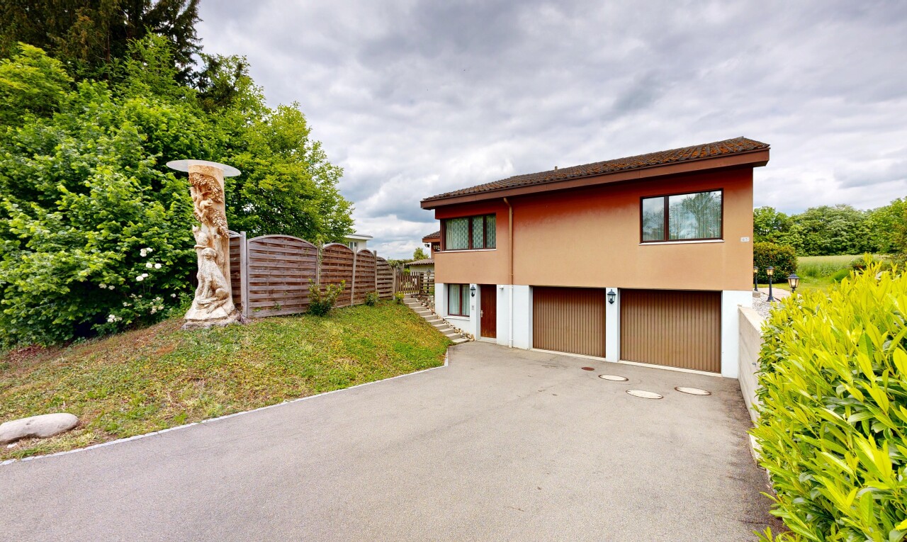 außenansicht mit overcast, eingebaute garage, auffahrt, rasen, und zaun