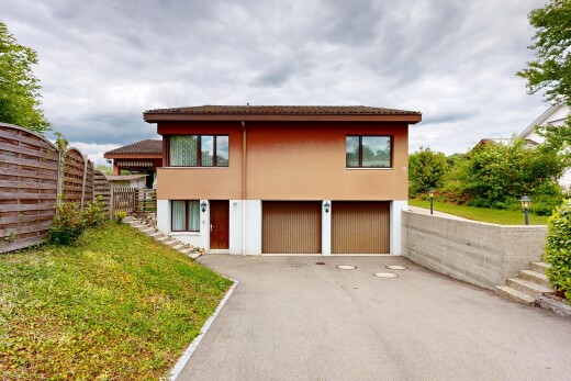 außenansicht mit overcast, eingebaute garage, auffahrt, zaun, und rasen