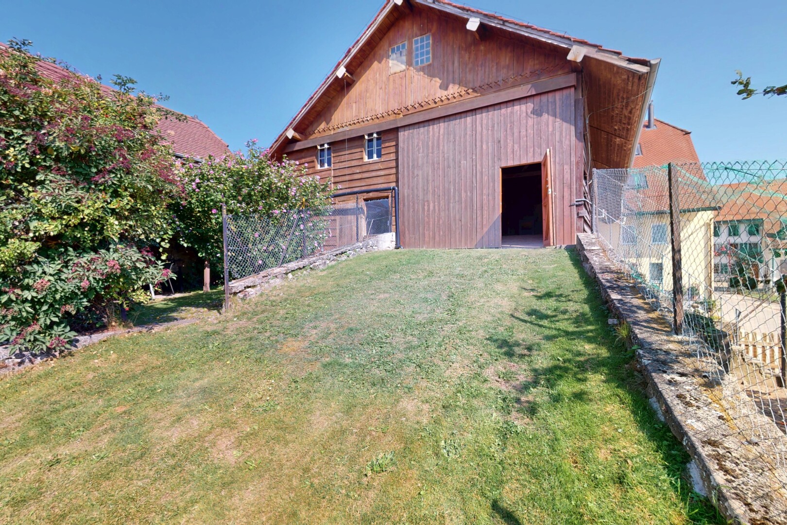 außenansicht mit holzverkleidung, rasen, vertikale verkleidung, property visible, und day time