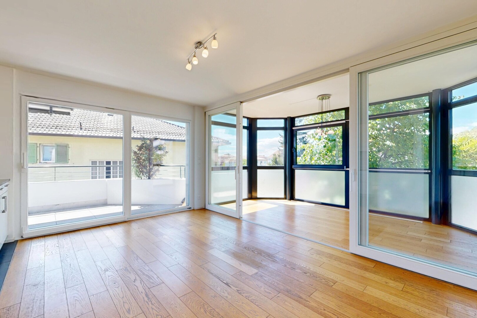 pièce vide avec éclairage sur rail, lumière naturelle, wood finish floor, sol en finition bois, et inside property