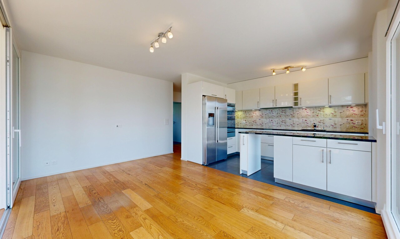 cuisine avec éclairage sur rail, dark countertops, plans de travail, réfrigérateur, et white cabinets