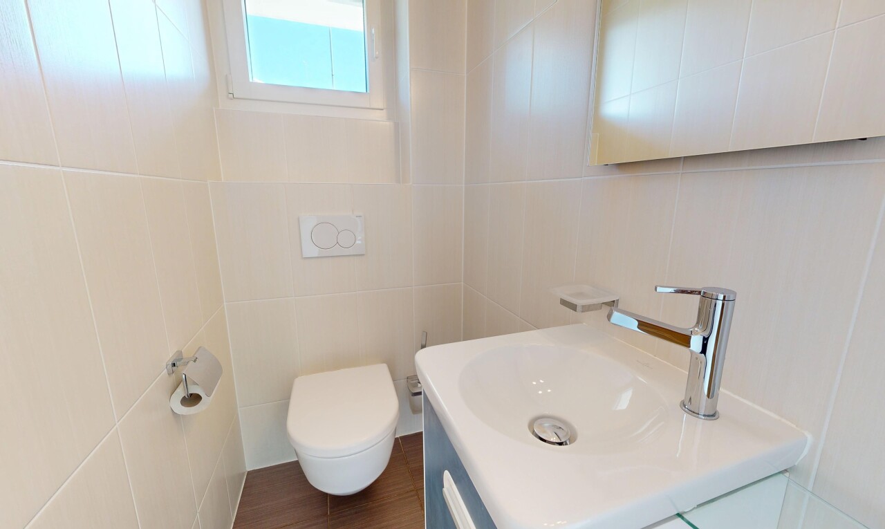 salle de bains avec lavabo (ou coiffeuse selon le contexte), tile wall, mur en carrelage, toilette, et inside property