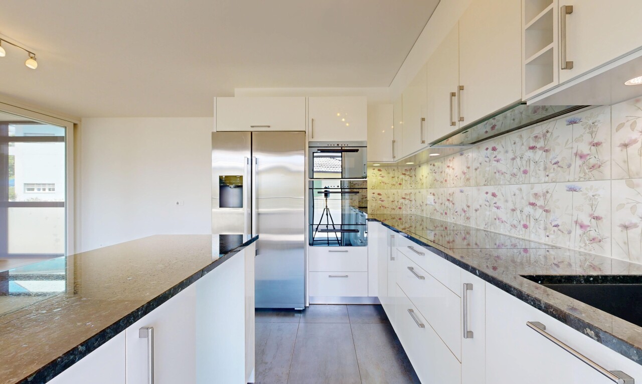 cuisine avec réfrigérateur, dark countertops, stone countertops, plans de travail en pierre, et white cabinets