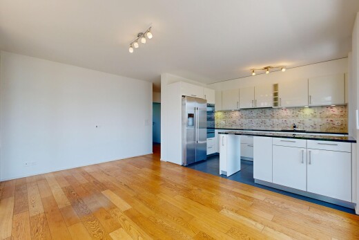 cuisine avec éclairage sur rail, dark countertops, plans de travail, réfrigérateur, et white cabinets