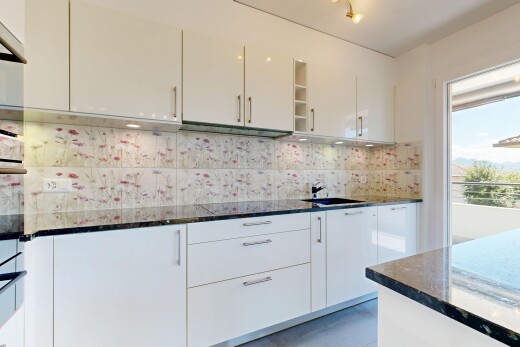 cuisine avec dark countertops, stone countertops, plans de travail en pierre, backsplash, et dosseret