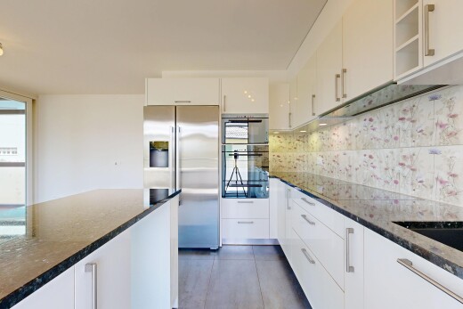 cuisine avec réfrigérateur, dark countertops, stone countertops, plans de travail en pierre, et white cabinets