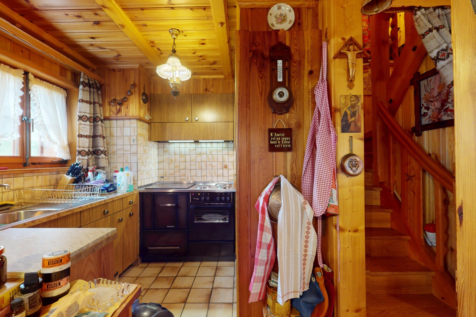 cuisine avec plans de travail, inside property, sol en carrelage, tile floor, et lumière naturelle
